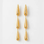 Varnika Arora Dewdrift Tier Drop earrings featuring layered gold-toned metal drops with intricate design details.