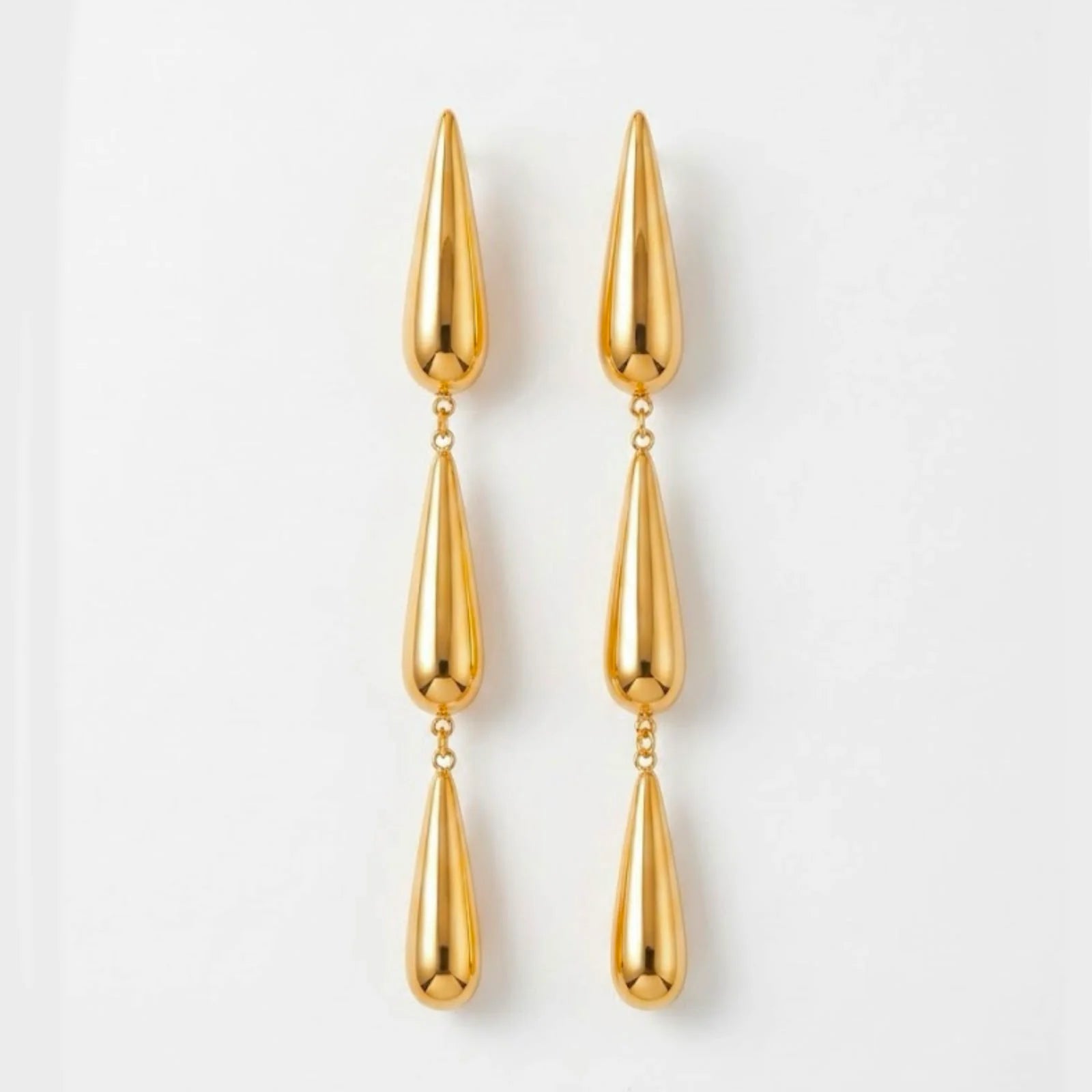 Varnika Arora Dewdrift Tier Drop earrings featuring layered gold-toned metal drops with intricate design details.