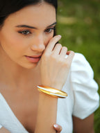 Varnika Arora white enamel gold bangle with intricate design, showcasing a stylish and elegant accessory for women's jewelry collection.