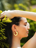 Varnika Arora Helixa green enamel gold hoops earrings with a shiny finish and round hoop design.