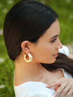 Varnika Arora Huma Qureshi Helixa white enamel gold hoops earrings, close-up view showing their elegant design and shiny finish