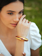 Maroon enamel gold bangle by Varnika Arora featuring a delicate circlet design with intricate gold detailing.