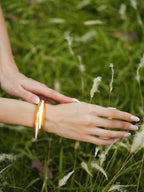 Varnika Arora white enamel gold bangle with intricate design, showcasing elegant jewelry craftsmanship and shiny finish.
