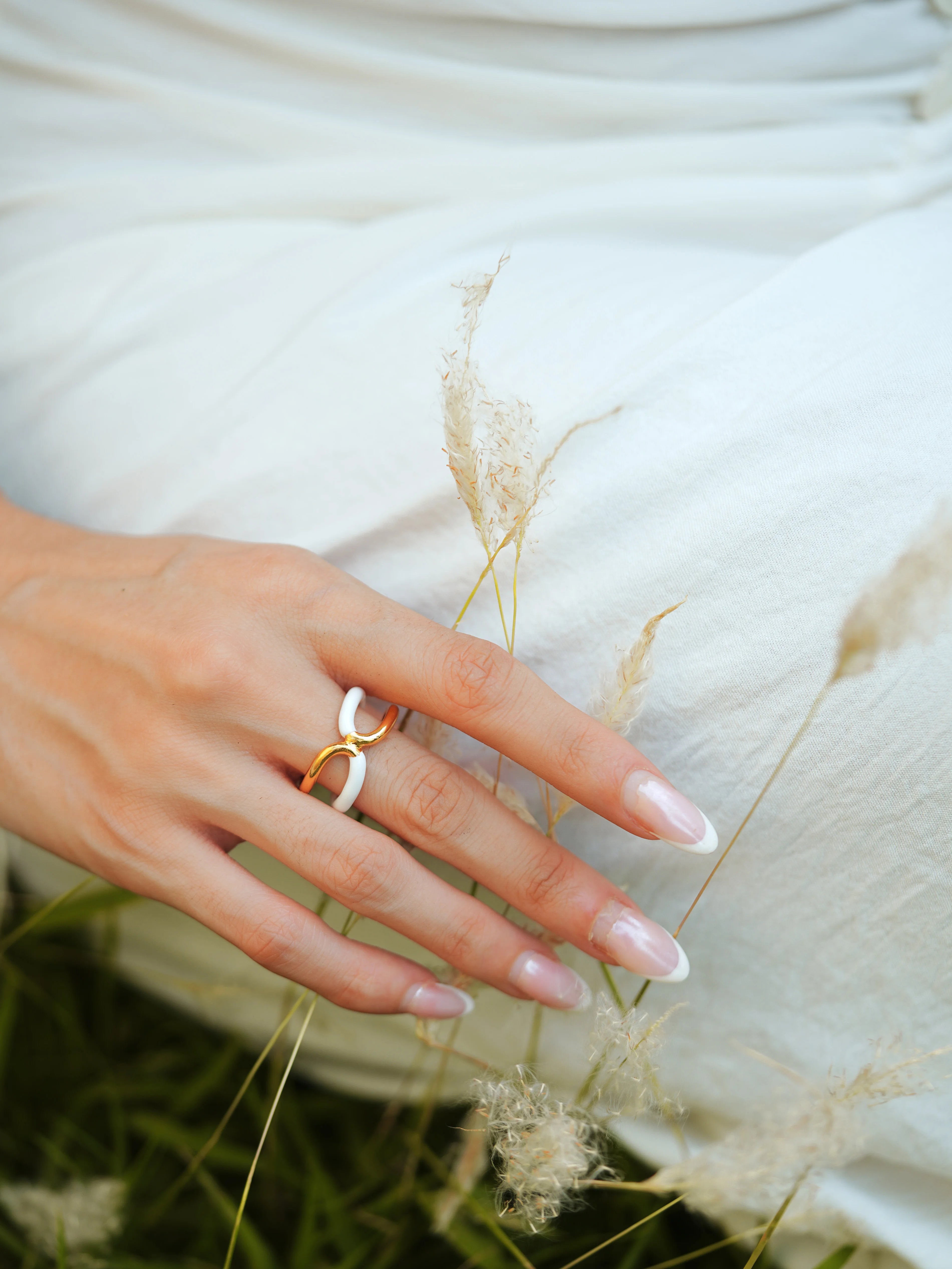 Varnika Arora Twistie 2-way white enamel gold ring with twisted design, showcasing elegant craftsmanship and versatile wear.