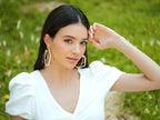 Large white enamel gold hoop earrings by Varnika Arora, showcasing bold, shiny hoops with a smooth enamel finish and gold accents.