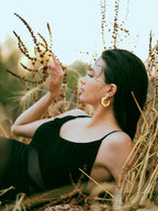 Varnika Arora Helixa black enamel gold hoop earrings displayed with their shiny black enamel finish and gold accents.