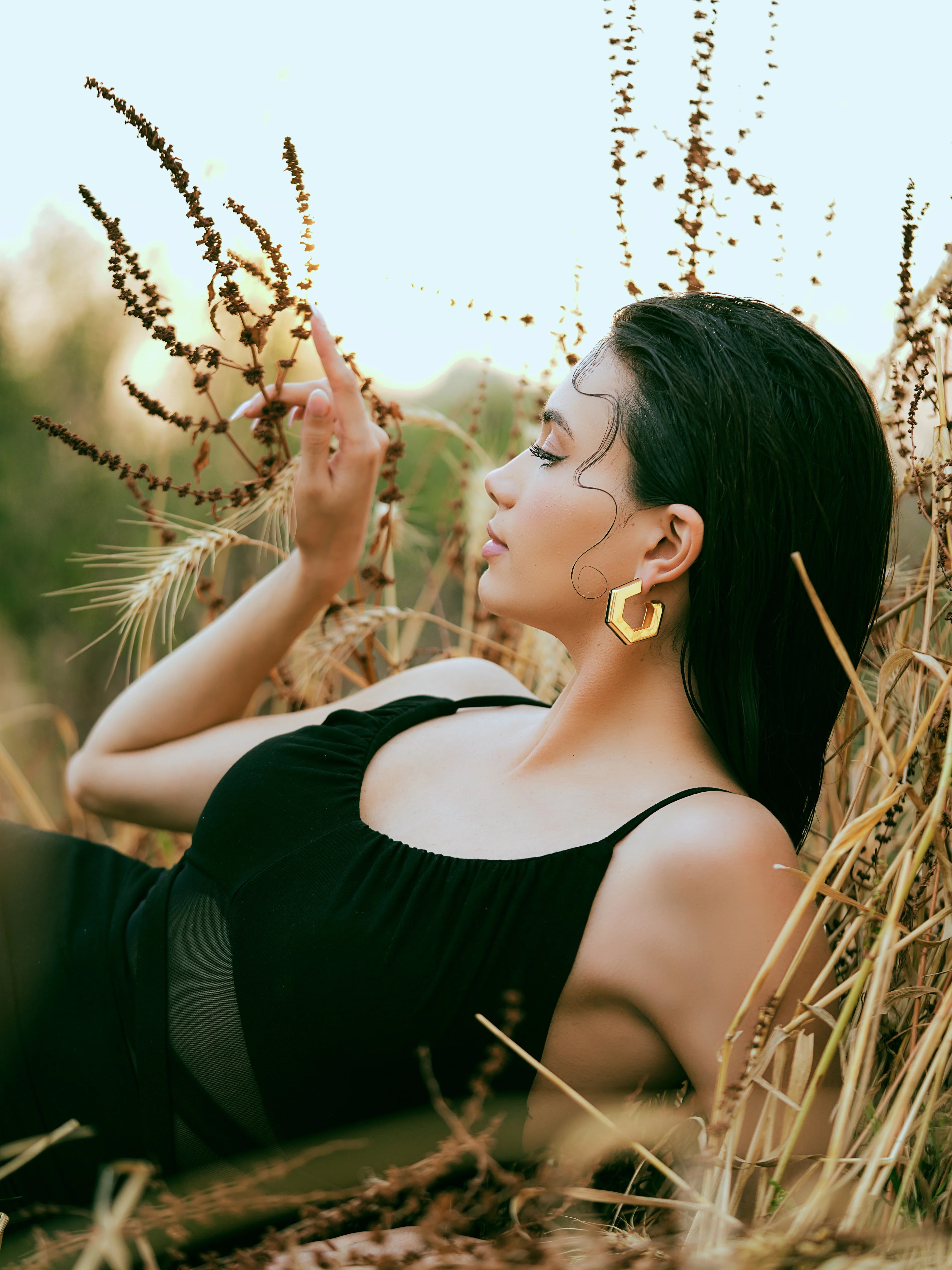 Varnika Arora Helixa black enamel gold hoop earrings displayed with their shiny black enamel finish and gold accents.
