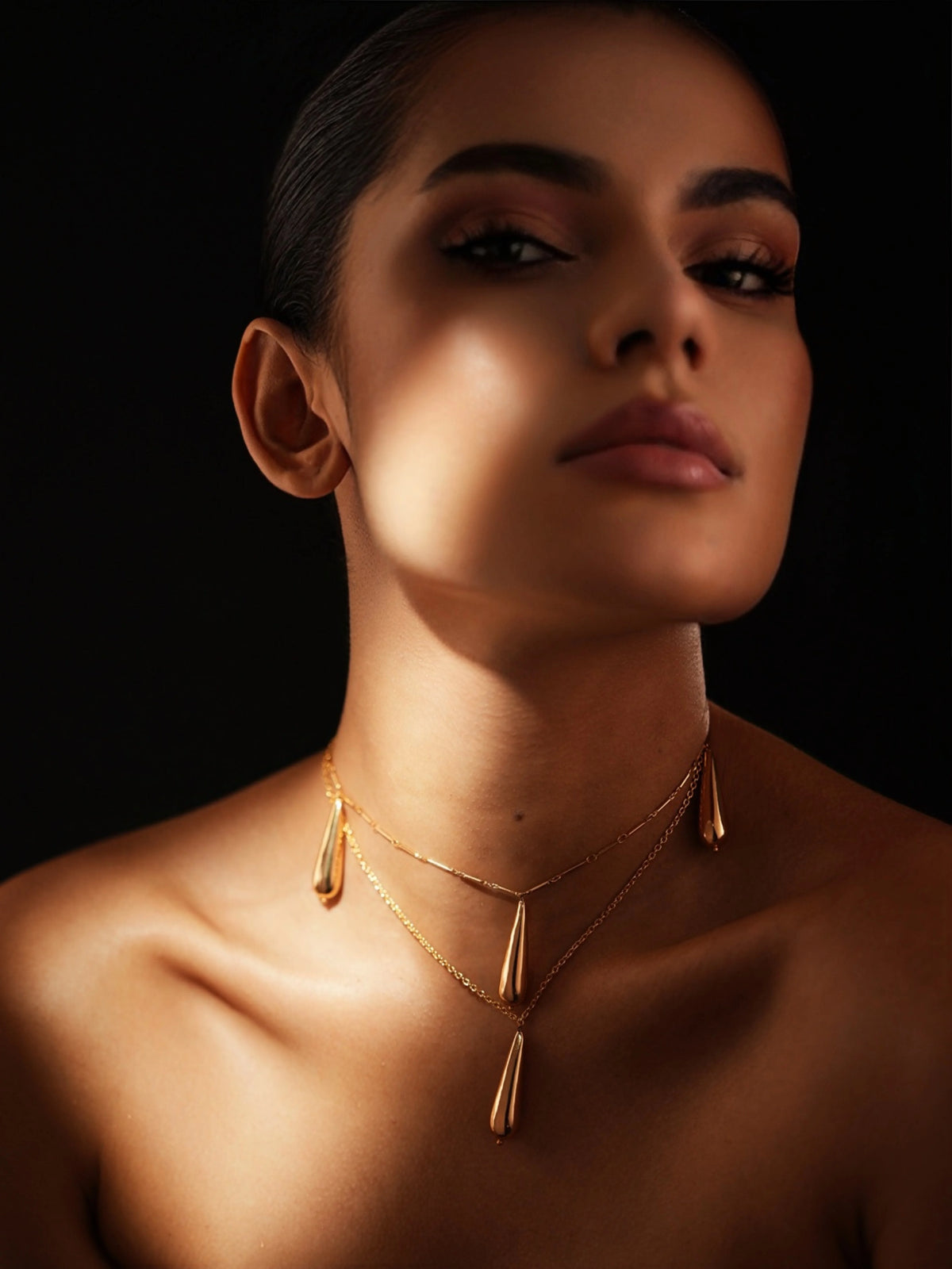 Dewdrop necklace by Varnika Arora featuring a delicate silver chain with a shimmering teardrop pendant.