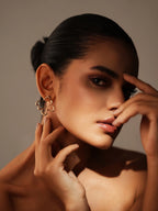 Varnika Arora Flutter studs, gold-tone earrings with intricate design, displayed on a white background