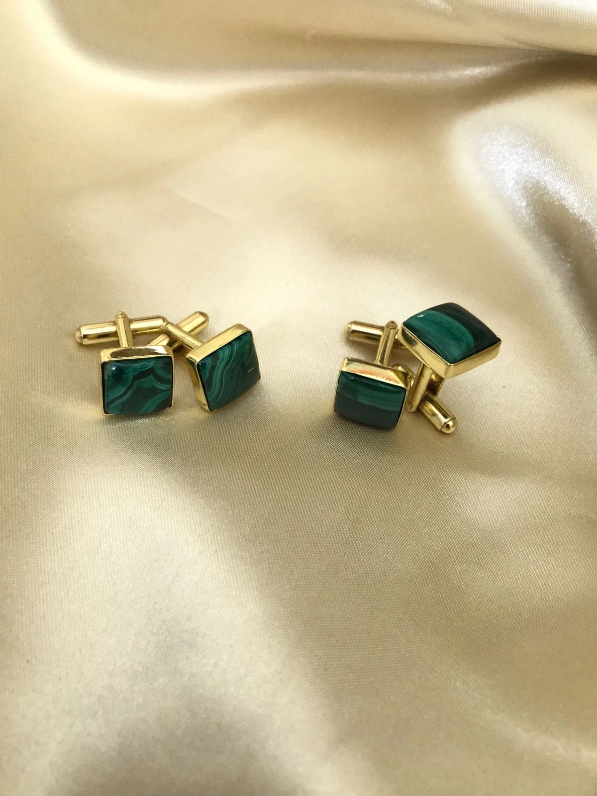 VARNIKA ARORA Malachite cufflinks in jewelry, featuring polished green malachite stones and silver-tone metal accents.